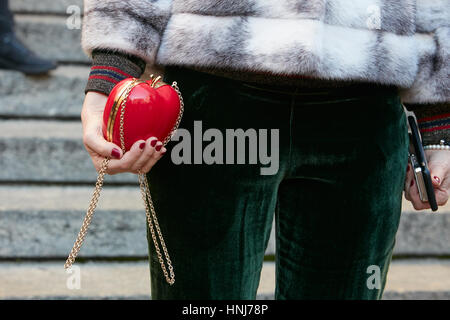 Jeune femme à la pomme et un pantalon en velours sac vert avant de Salvatore Ferragamo fashion show, Milan Fashion Week street style sur janvier 2017. Banque D'Images