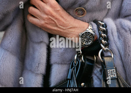Femme avec Rolex Submariner watch et manteau de fourrure gris avant de Salvatore Ferragamo fashion show, Milan Fashion Week street style sur janvier 2017. Banque D'Images