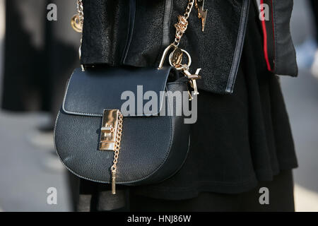 Femme avec sac en cuir noir avec détails dorés avant de Giorgio Armani fashion show, Milan Fashion Week street style le 17 janvier Banque D'Images