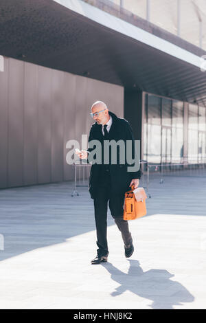 Moyen-âge homme contemporain piscine dans la ville, à l'aide de smart phone main courante - entreprises, travail, communication concept Banque D'Images