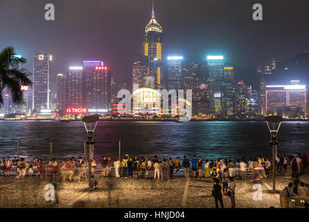 HONG KONG - le 2 octobre 2015 : les gens, capturé avec blurred motion, profitant de la célèbre ligne d'horizon de Hong Kong à partir de l'Avenue des Stars à Kowloon dans la nuit Banque D'Images