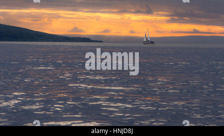 Brean Down coucher de soleil derrière dans le canal de Bristol, avec yacht. Ciel et nuages spectaculaires vu de Weston-super-Mare dans le Somerset, Royaume-Uni, avec le fort Banque D'Images