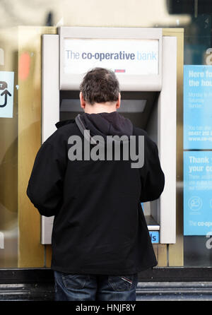 Une personne utilise un distributeur de billets à la Co-operative Bank à Islington, Londres. Le conseil d'administration de la Co-operative Bank a levé une vente pour signer sur le prêteur en difficulté en ce qui concerne monter sur la situation de son capital. Banque D'Images