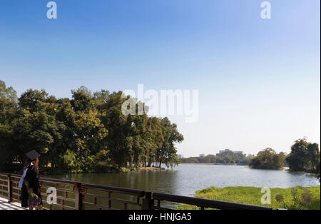 Chiang Mai, Thaïlande - 19 janvier 2016 : femme en toge debout sur le pont sur l'étang de l'Université Chiang Mai à Chiang Mai, Thaïlande Banque D'Images