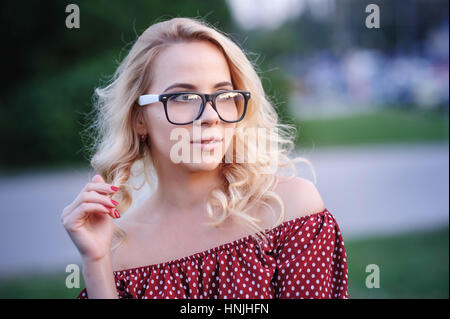 Jeune femme à lunettes sur un fond du lac Banque D'Images