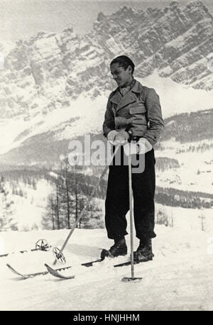 Cortina, Italie - 1937 -Vintage portrait d'un skieur avec un beau paysage d'hiver la montagne derrière. Numérisation à partir de la photographie analogique, la collection de la famille privée avant la DEUXIÈME GUERRE MONDIALE. Banque D'Images