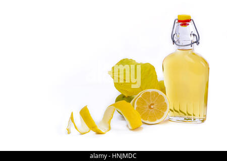 Carafe en verre ouvrir la bouteille et verre rempli de liqueur de citron jaune ou limoncello ou limoncino sur blanc. Citron Bio naturel pelées. Banque D'Images