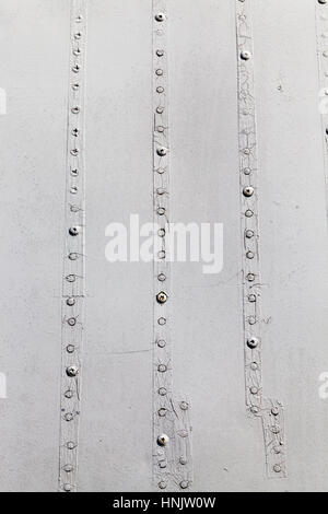 La surface métallique de l'ancien avion inutilisés gris. Dans la peinture, certains dommages visibles, ainsi que des rivets et boulons qui maintiennent les feuilles de matériau. Petites d Banque D'Images