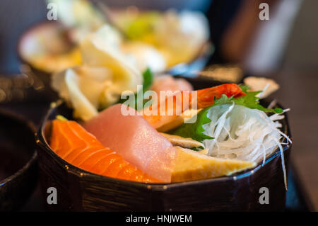 Libre de Japonais sashimi chirashi bol à riz avec crevettes (EBI), maguro (thon), sake (saumon) et des oeufs (omelettes tamago). L'accent délibéré et sh Banque D'Images