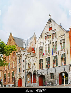 L'étroite façade du péage médiéval, décoré de sculptures et d'historique des armoiries, Jan van Eyck Square, Bruges, Belgique. Banque D'Images