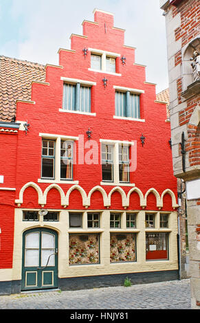 Le rouge vif de la façade de style néo-flamand maison avec le toit en mansarde, situé dans la ville historique de Patershol près de Gand, Belgique. Banque D'Images