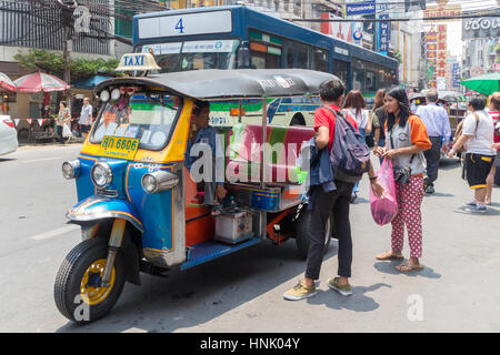 Les passagers de négocier un tarif avec un tuk tuk dans Chinatown, Bangkok, Thaïlande Banque D'Images