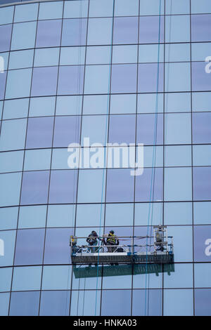 Les travailleurs sur une scène swing réparer windows sur une tour à bureau. Banque D'Images