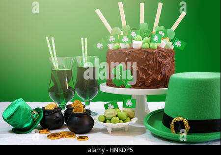 Happy St Patricks Day, le 17 mars, vert et blanc tableau parti avec showstopper gâteau au chocolat décoré avec des bonbons, des biscuits et des drapeaux irlandais. Banque D'Images