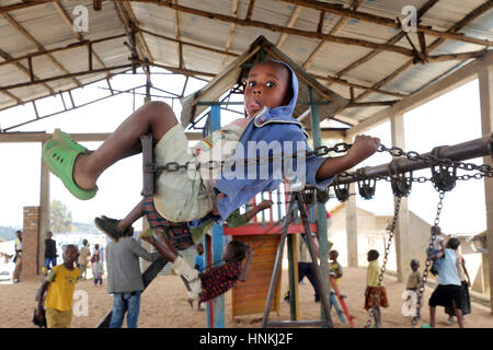 Garçon sur une balançoire, aire de jeux pour enfants dans le camp de réfugiés, Kigeme diocèse de Gikongoro, au Rwanda, en Afrique Banque D'Images