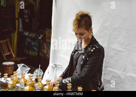 Camden fashion : un punk à l'étal au visiteur avec parfums à Camden, Londres, Royaume-Uni. Banque D'Images