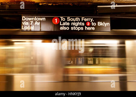 A New York City Metro trains grâce à une station dans le lower Manhattan. Le mouvement des trains est floue mais les passagers en attente ne peut être vu. Banque D'Images