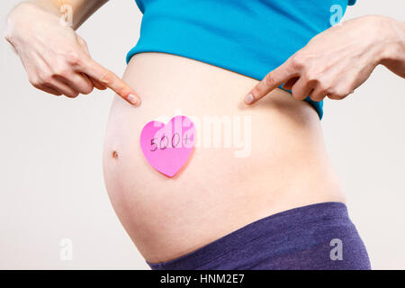 Femme enceinte montrant feuille de papier avec l'inscription 500 +, programme social et politique en Pologne Banque D'Images