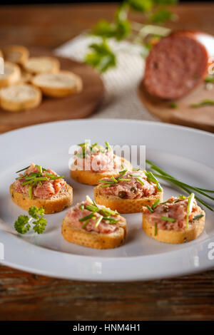 Salé, fumé teewurst une saucisse allemande fait de bacon et de porc, sur des biscottes pain de ciboulette Banque D'Images