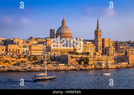 La Valette, Malte - Voiliers et la célèbre Cathédrale St Paul avec l'ancienne ville de La Valette au coucher du soleil Banque D'Images