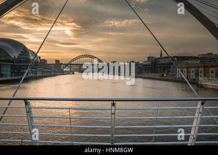 Coucher du soleil à l'hiver le long de la rivière Tyne vers Pont Tyne de Gateshead Millennium Bridge, à Newcastle-upon-Tyne, Tyne et Wear, Angleterre Banque D'Images