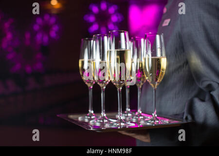 Waiter serving champagne sur un plateau Banque D'Images