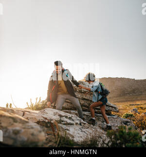 Jeune couple à aider les uns les autres dans les montagnes. Young male hiker aider amie tandis que le trekking en montagne. Banque D'Images