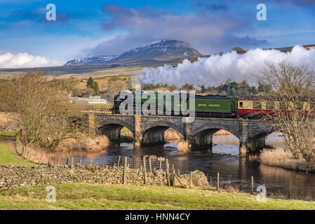 Pont Helwith. Yorkshire du Nord. Nord-Ouest de l'Angleterre. Mercredi 15 février 2017. La machine à vapeur de Peppercorn Tornado le deuxième jour de transport de trains réguliers entre Skipton et Appleby sur le plateau de Carlisle Railway. Les services sont les premiers schedueld vapeur transporté sur le rail britannique depuis 50 ans. Le train est photographié passant par le pont Helwith avec l'imposant Pen y Ghent en arrière-plan. Photo par Andrew Davidson. Banque D'Images