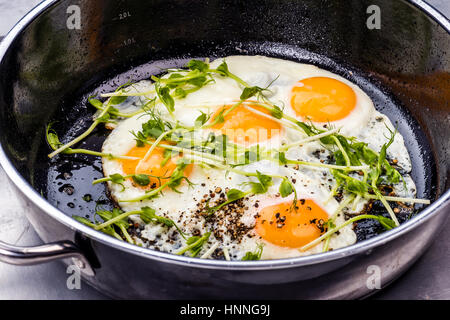 Oeufs au plat soutenu avec les pois frais sprouting Banque D'Images