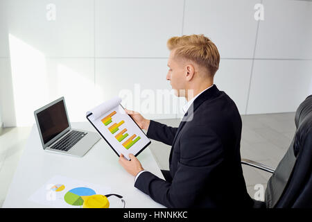 Man à son bureau avec un ordinateur portable dans le bureau Banque D'Images