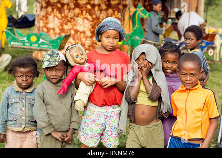 Groupe d'enfants malgaches posent à l'avant du carrousel dans le parc d'amusement. Banque D'Images