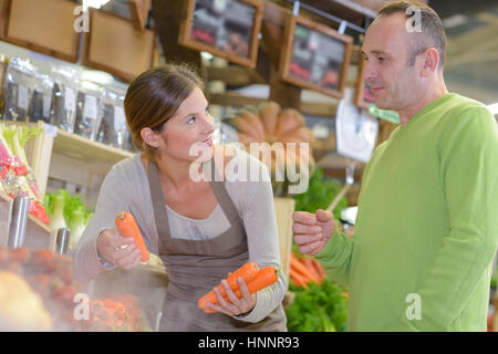 Assistante commerciale avec le client, holding carrots Banque D'Images