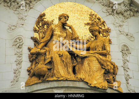 Belle sculpture de deux femmes en or sur le mur d'un bâtiment Banque D'Images