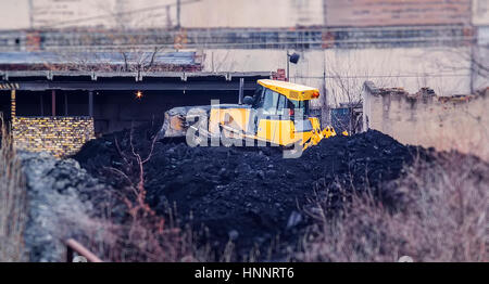 Le tracteur travaille à proximité de l'ancienne usine Banque D'Images