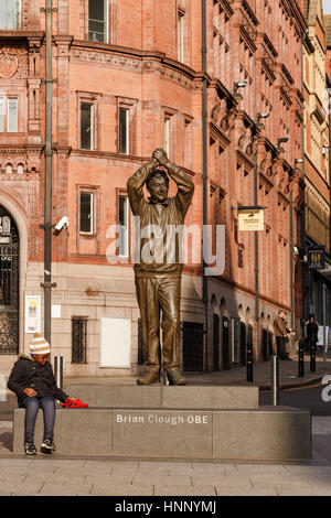 Nottingham, Angleterre - 13 février : petit noir / afro-caribéenne garçon assis à côté de Brian Clough statue à Nottingham. à Nottingham, Angleterre. sur 13t Banque D'Images