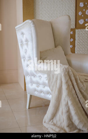 Chaise blanche avec une couverture dans le studio Banque D'Images