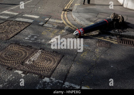 Un détail de la surface de la route où un bollard endommagé se trouve à l'horizontal, renversé par un véhicule le 13 février 2017, dans la ville de Londres, Royaume-Uni. Banque D'Images