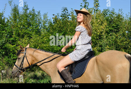 Jolie jeune fille l'équitation de l'été journée ensoleillée Banque D'Images