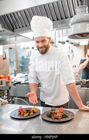 Portrait de chef cuisinier en uniforme avec prepaired plat délicieux au restaurant cuisine Banque D'Images