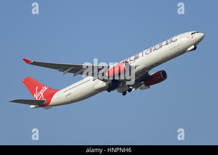 Virgin Atlantic Airways Airbus A330-343 G-VKSS 'Mademoiselle' rouge décollant de l'aéroport Heathrow de Londres, dans le ciel bleu Banque D'Images