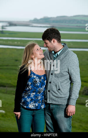 Un couple engagé récemment montrent leur amour pour l'autre près de sept sœurs, East Sussex, UK. Banque D'Images