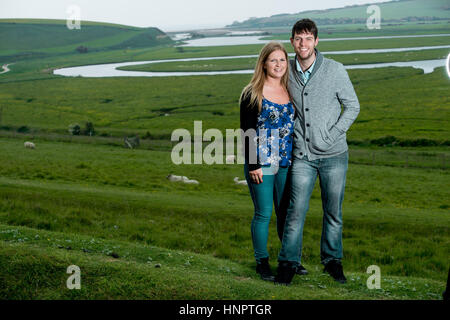 Un couple engagé récemment montrent leur amour pour l'autre près de sept sœurs, East Sussex, UK. Banque D'Images