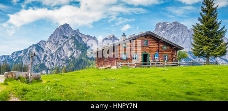 Vue panoramique du paysage de montagne idyllique dans les Alpes avec chalet de montagne traditionnel et les pâturages de montagne verte avec des fleurs en été Banque D'Images