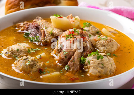 Soupe de boulettes de viande de poulet et les herbes dans un bol blanc Banque D'Images