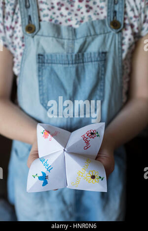 Une fille avec un jeu papier Origami Fortune Teller Banque D'Images