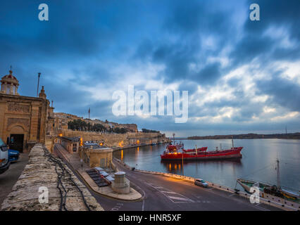La Valette, Malte - Belle aube matin et lumières à l'anciens murs de Valletta Waterfront avec les navires et nice nuages bleus Banque D'Images