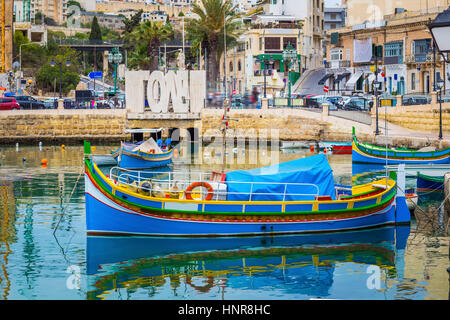 St.Julians, Malte - bateau de pêche colorés traditionnels Luzzu à Spinola Bay au lever du soleil Banque D'Images