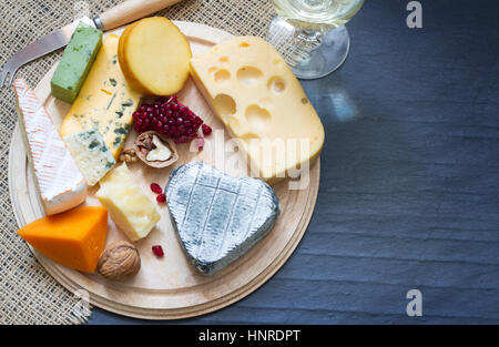 Différents types de fromage sur la fréquence cardiaque avec verre de vin sur fond de marbre noir Banque D'Images