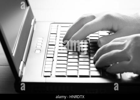 Ordinateur hacker en gants blancs de voler des informations sur l'ordinateur portable Banque D'Images