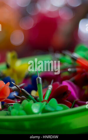 Fléchettes plastique en couleur dans un bol en plastique à un marché de rue. Banque D'Images